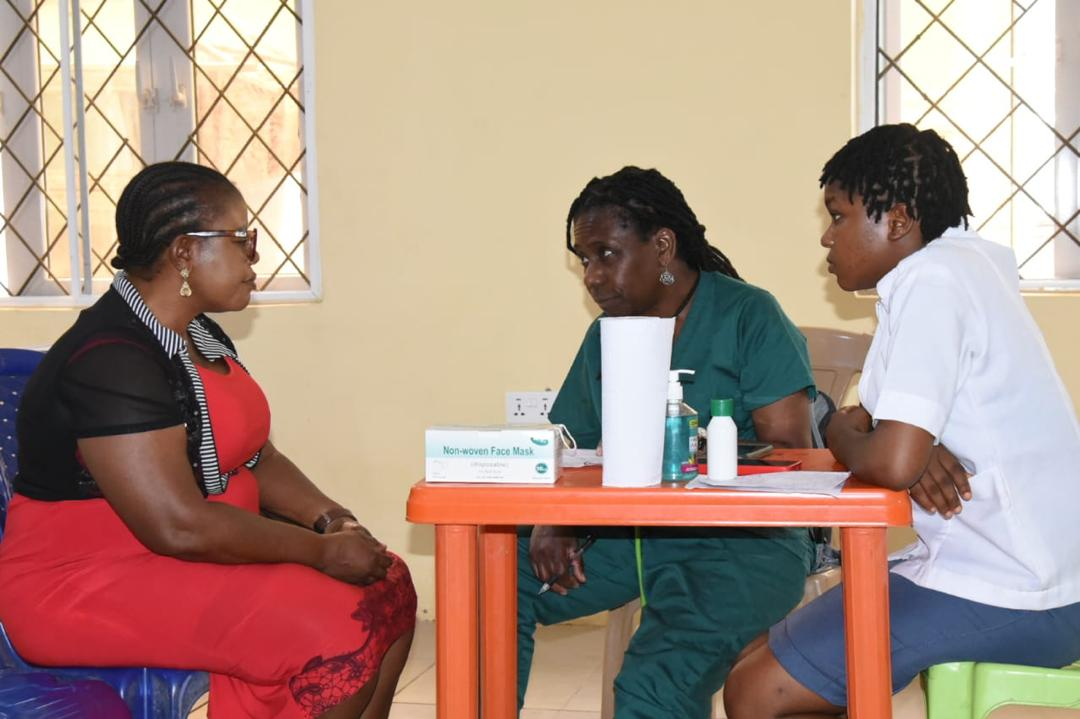 A mission doctor in green scrubs and a nurse consulting with a patient at an outpatient clinic during the 2025 Abia Global Medical Mission.